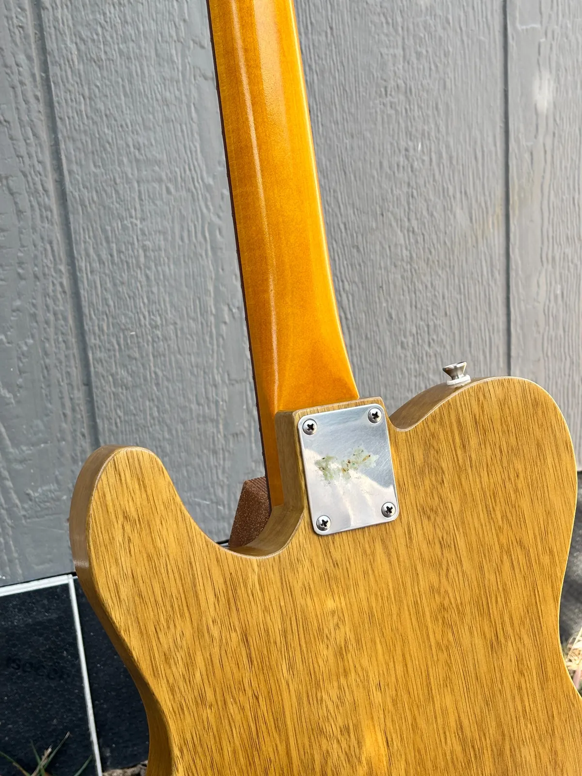 Plume neck heel and neck plate detail on the back of the guitar.